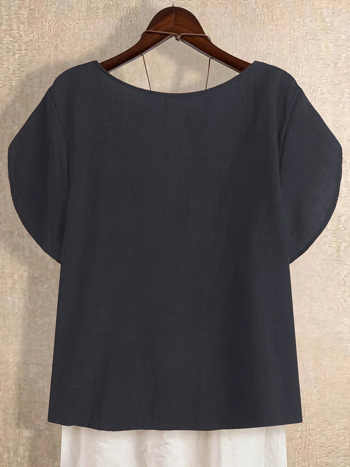 Plus-size women's asymmetrical solid color T-shirt with unique button detail, featuring a comfortable loose fit, suitable for ca
