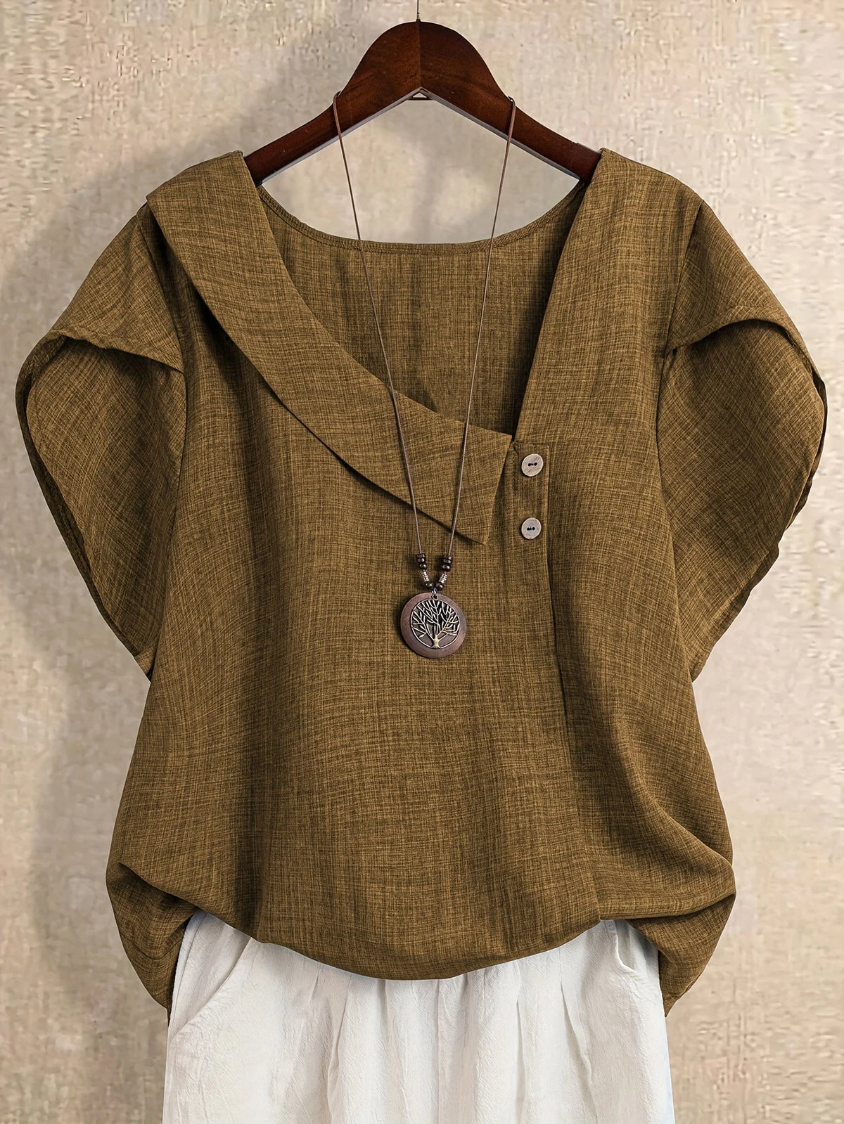Plus-size women's asymmetrical solid color T-shirt with unique button detail, featuring a comfortable loose fit, suitable for ca