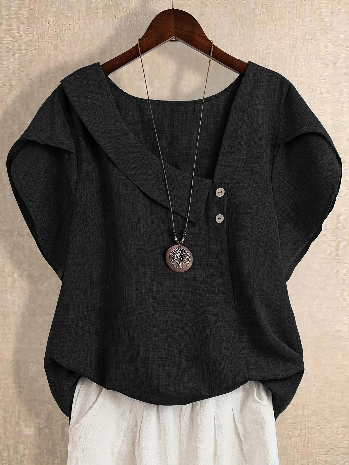 Plus-size women's asymmetrical solid color T-shirt with unique button detail, featuring a comfortable loose fit, suitable for ca